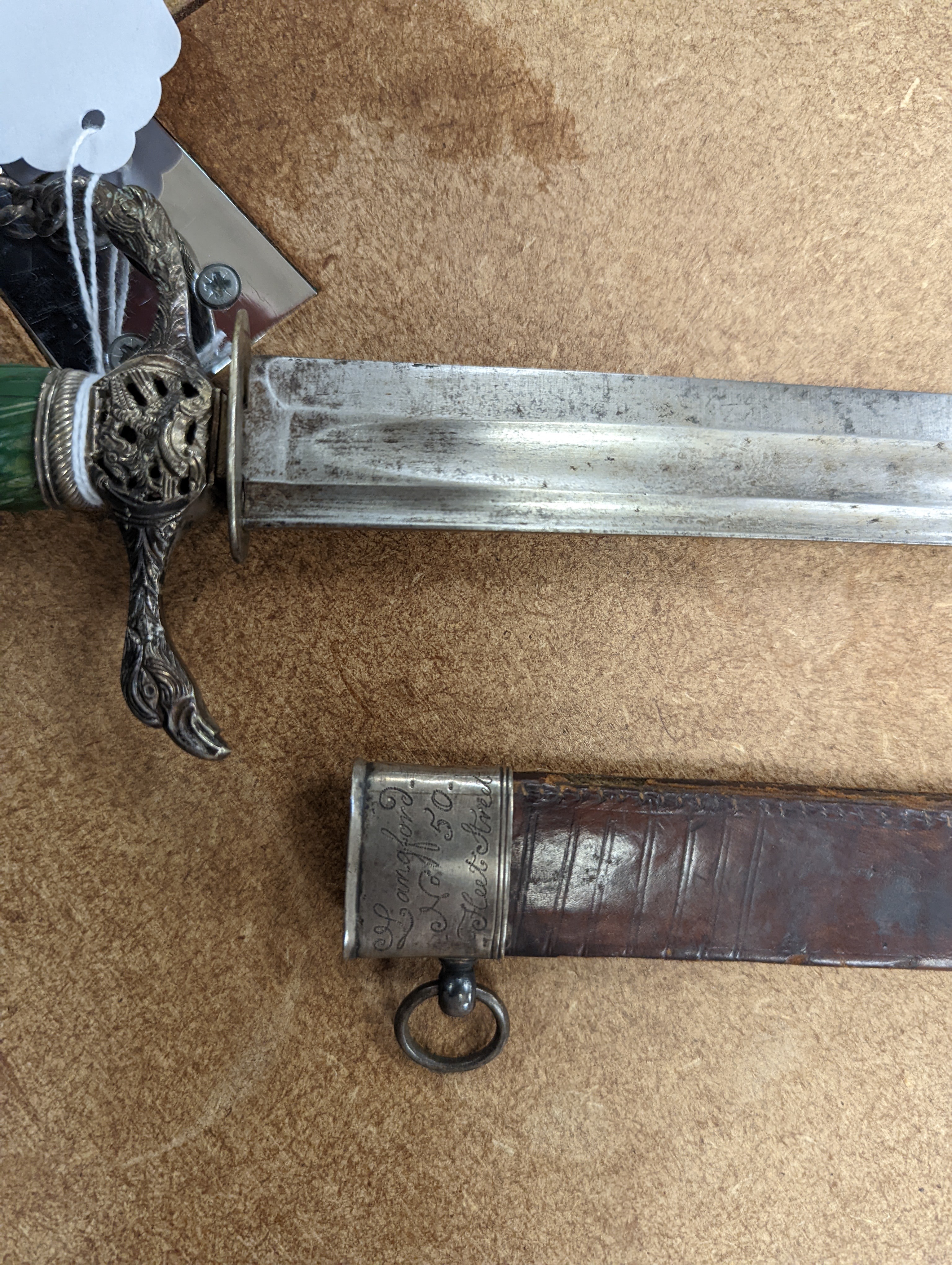 An English silver hilt hanger c.1770, London, maker M.B (year letter indistinct) eagle head pommel and crosspiece finials, spiral carved, green-stained ivory grip, curved fullered blade 63cms, retaining the top of its si